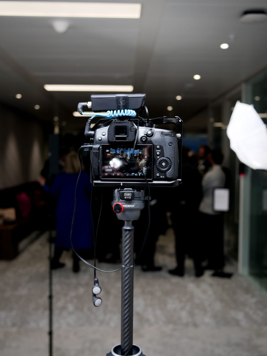 Close-up of the cinema camera and audio rig set up on a tripod at an event.